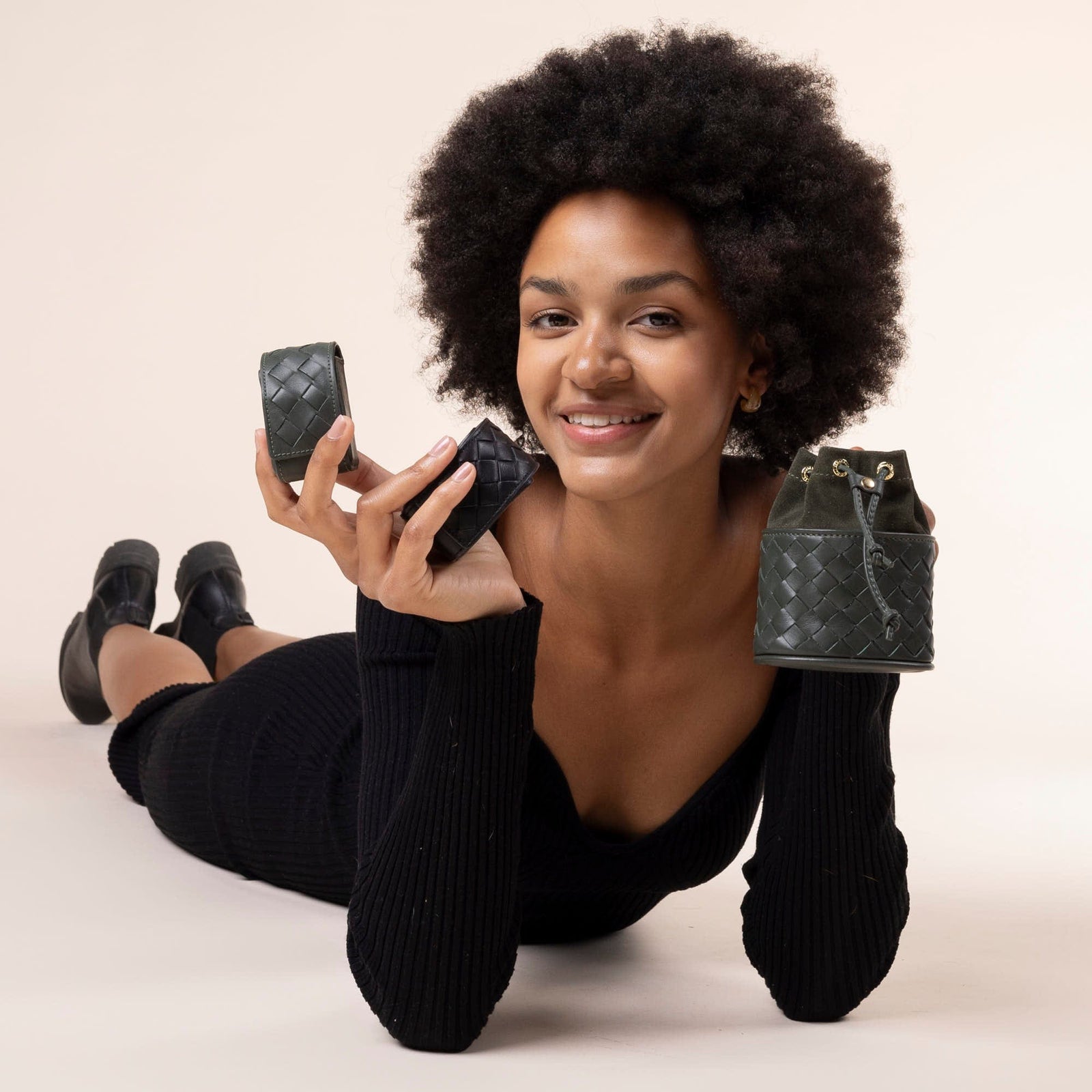 Frau hält Kotbeutelspender in dunkelgrün und schwarz aus geflochtenem  Leder und Leckerlibeutel in dunkelgrün aus geflochtenem Leder